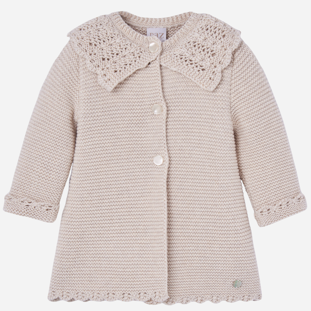 Sold at Bombon shop, designed by Paz Rodriguez. Beige knit coat with openwork scalloped collar and pearlescent buttons down the front.