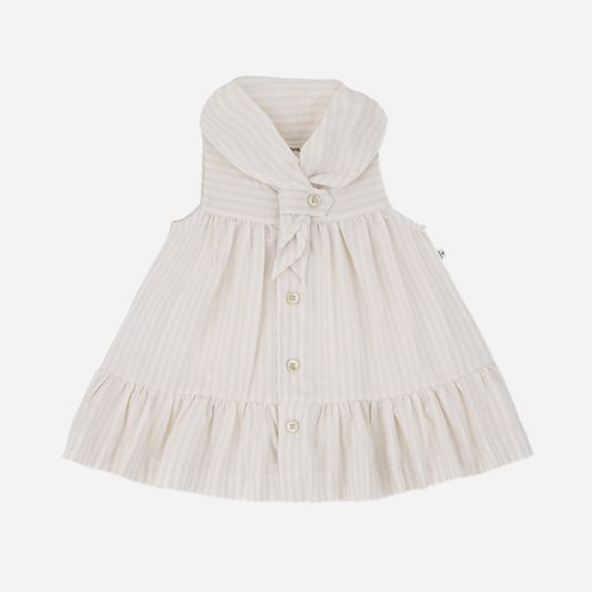Sold at Bombon Shop, designed by 1+ in the family, beige baby dress with textured vertical stripe cotton fabric and sailor-style collar.