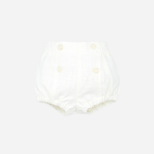 Sold at Bombon shop, designed by Fina Ejerique brand, white linen button shorts for baby perfect for spring and summer. Front view