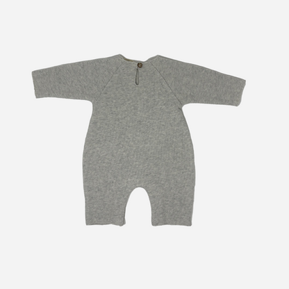 Sold at Bombon shop, designed by Tiny Soul — grey cotton baby romper with “a star is born” embroidery and bottom snap closures. back