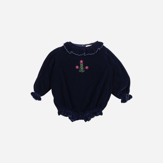 Sold at Bombon shop, this baby girl romper by The New Society is crafted in deep navy velvet with gathered hems, ruffled collar and cuffs, and floral embroidery on the chest—perfect for a festive or special occasion look. front