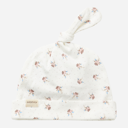 Sold at Bombon shop, designed by MarMar Copenhagen — white organic cotton baby hat with floral print and top knot, part of a matching set.