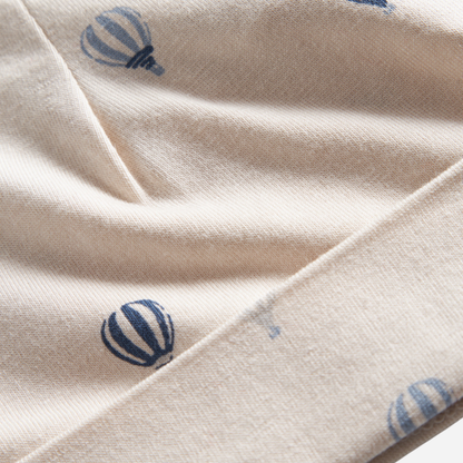 Sold at Bombon shop, designed by MarMar Copenhagen. Cream baby blanket with blue air balloon print, pairs perfectly with the matching air balloon hat and wrap footie.