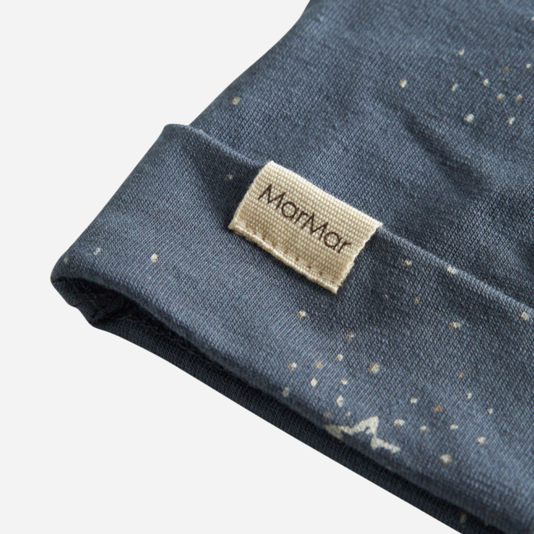 Sold at Bombon shop, designed by MarMar Copenhagen. Midnight blue baby hat with white star print, pairs perfectly with the matching wrap footie and blanket.