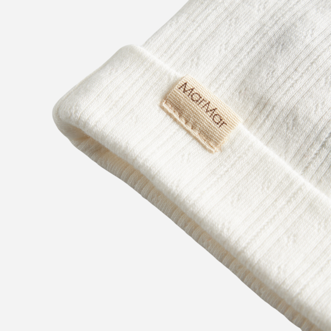 Sold at Bombon shop, designed by MarMar Copenhagen. Cream white ribbed baby hat, pairs perfectly with the matching wrap footie and blanket.