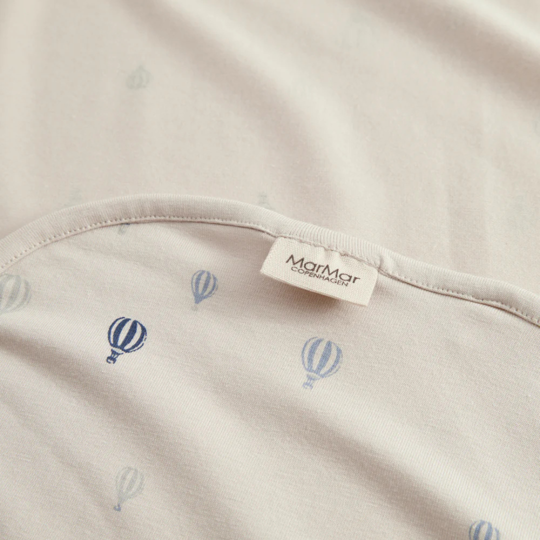 Sold at Bombon shop, designed by MarMar Copenhagen. Cream wrap footie with blue air balloon print, pairs perfectly with the matching air balloon hat and blanket.