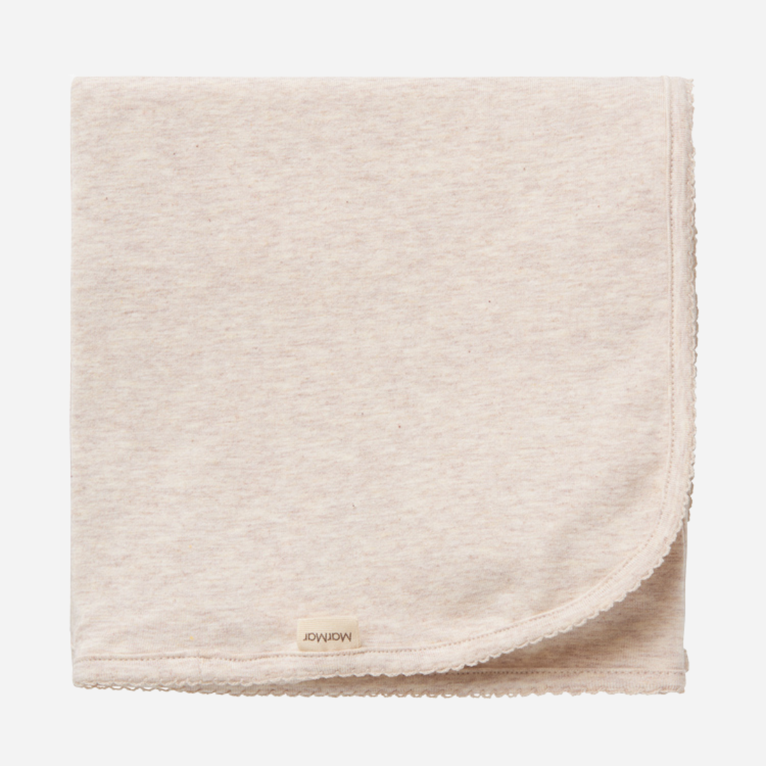 Sold at Bombon shop, designed by MarMar Copenhagen — beige organic cotton baby blanket with scalloped edge.