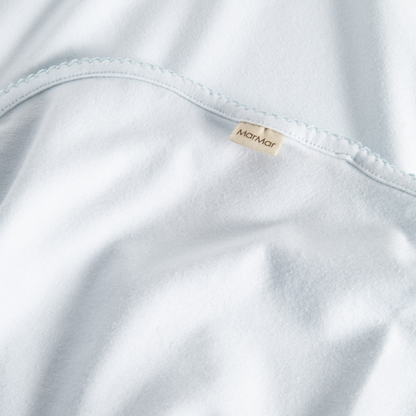Sold at Bombon shop, designed by MarMar Copenhagen — powder blue organic cotton baby blanket with scalloped edge.