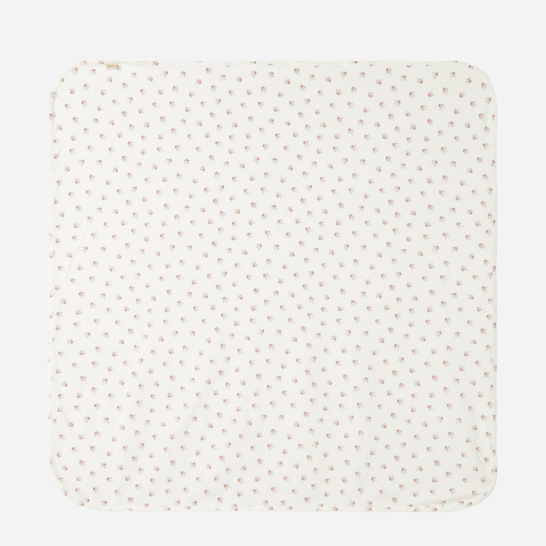 Sold at Bombon shop, designed by MarMar Copenhagen — white organic cotton baby blanket with floral print, part of a matching set.