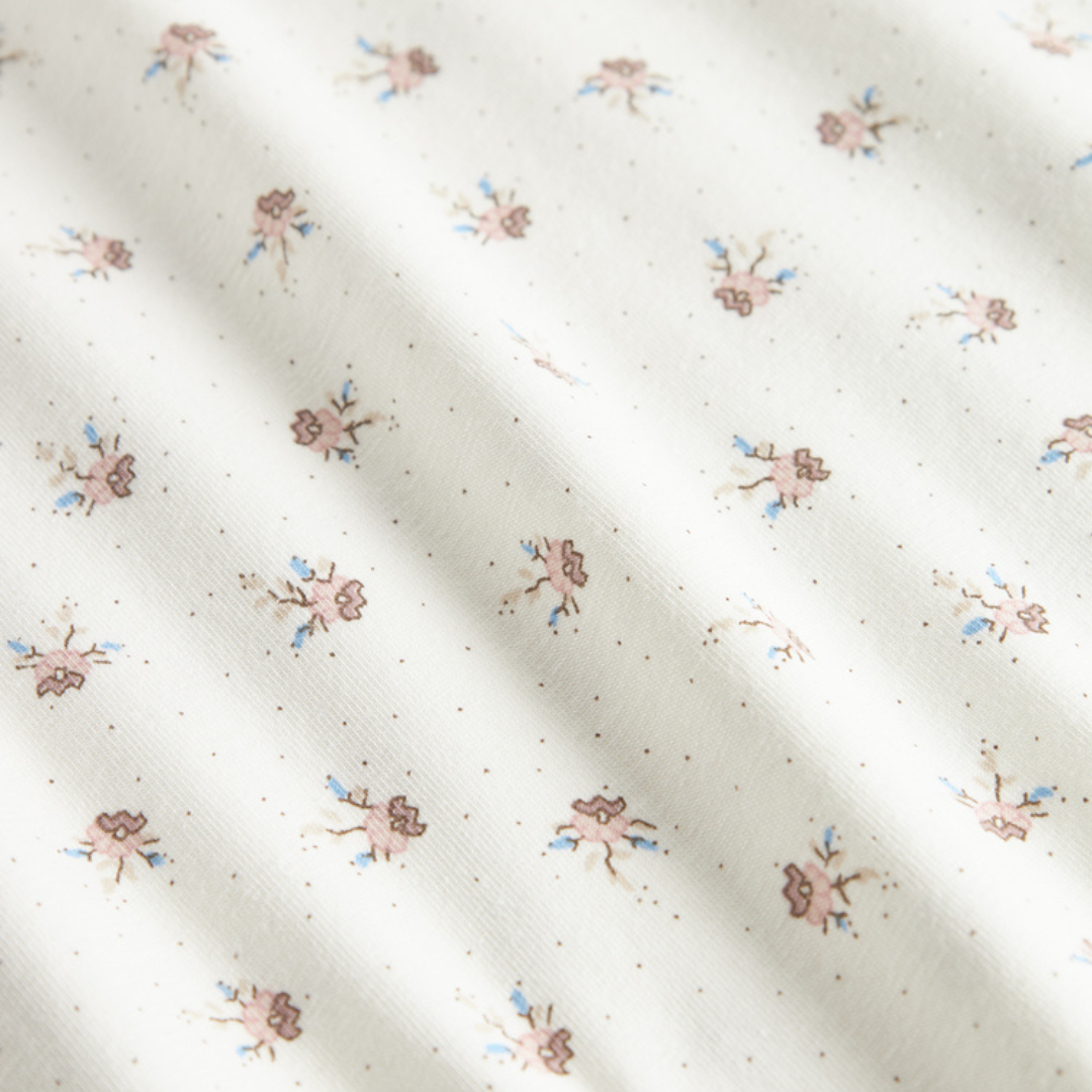 Sold at Bombon shop, designed by MarMar Copenhagen — white organic cotton baby blanket with floral print, part of a matching set.