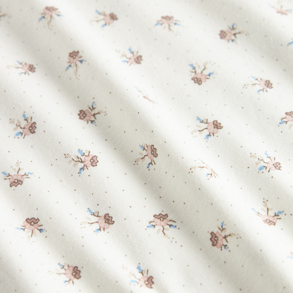 Sold at Bombon shop, designed by MarMar Copenhagen — white organic cotton baby blanket with floral print, part of a matching set.