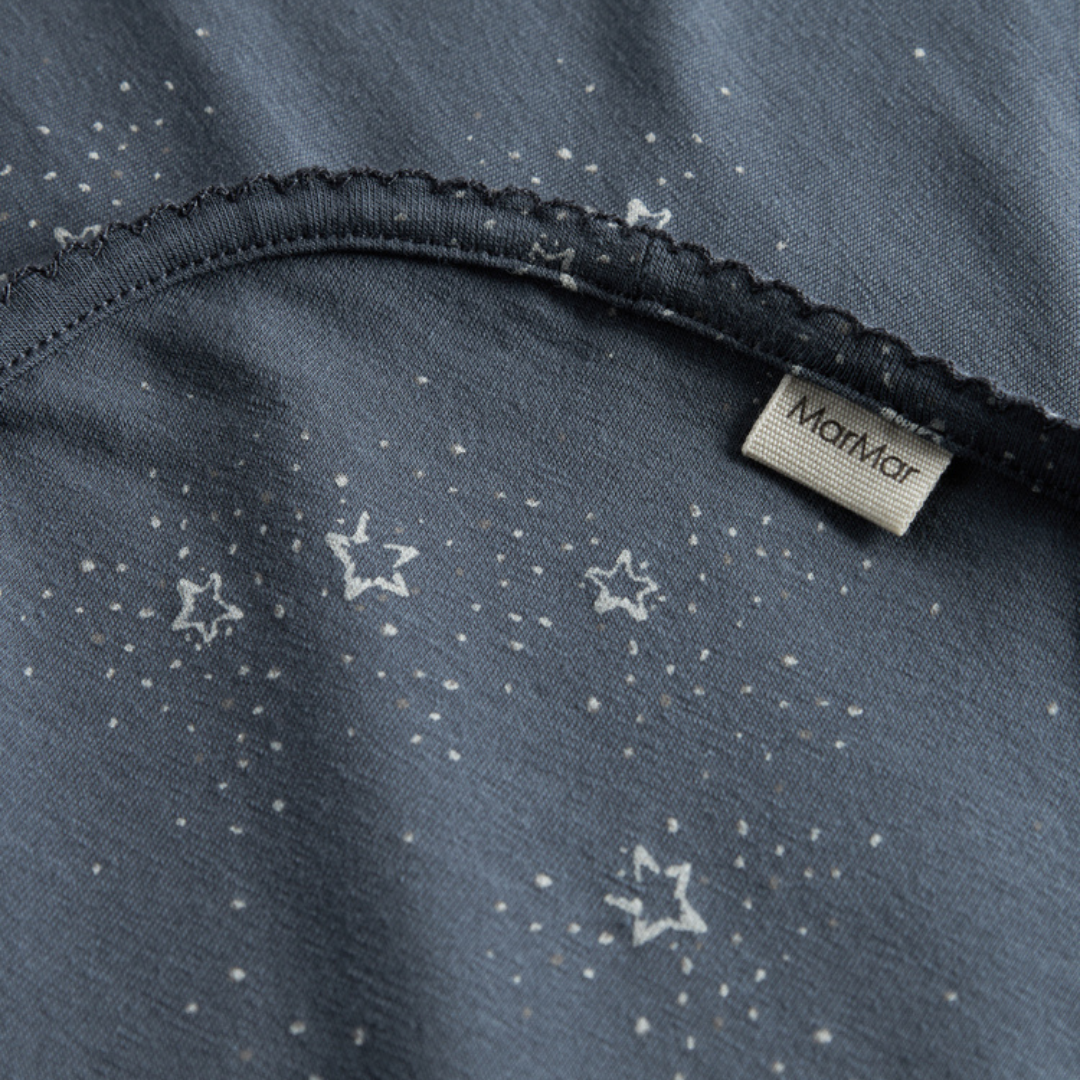 Sold at Bombon shop, designed by MarMar Copenhagen. Midnight blue baby blanket with white star print, pairs perfectly with the matching wrap footie and hat.
