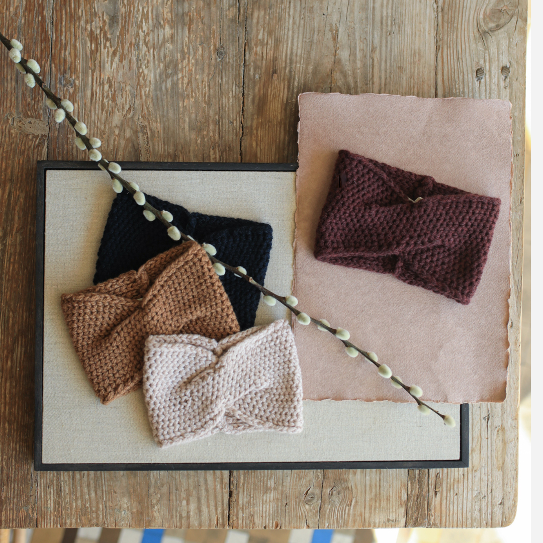 Sold at Bombon shop, designed by 1+ in the family — deep aubergine knit bandana with a twist front, crafted for warmth and comfort. lifestyle