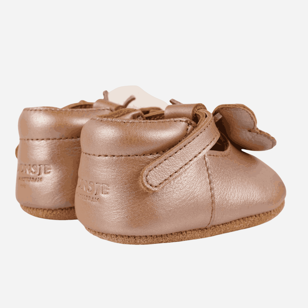 Sold at Bombon shop, designed by Donsje from Amsterdam, these butterfly detail, metallic rose shoes for baby girls are perfect to complete any outfit and keep the little feet comfortable all day. back view