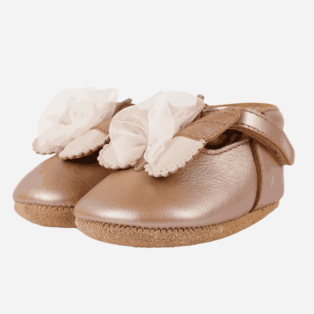 Sold at Bombon shop, designed by Donsje from Amsterdam, these butterfly detail, metallic rose shoes for baby girls are perfect to complete any outfit and keep the little feet comfortable all day. Side view.