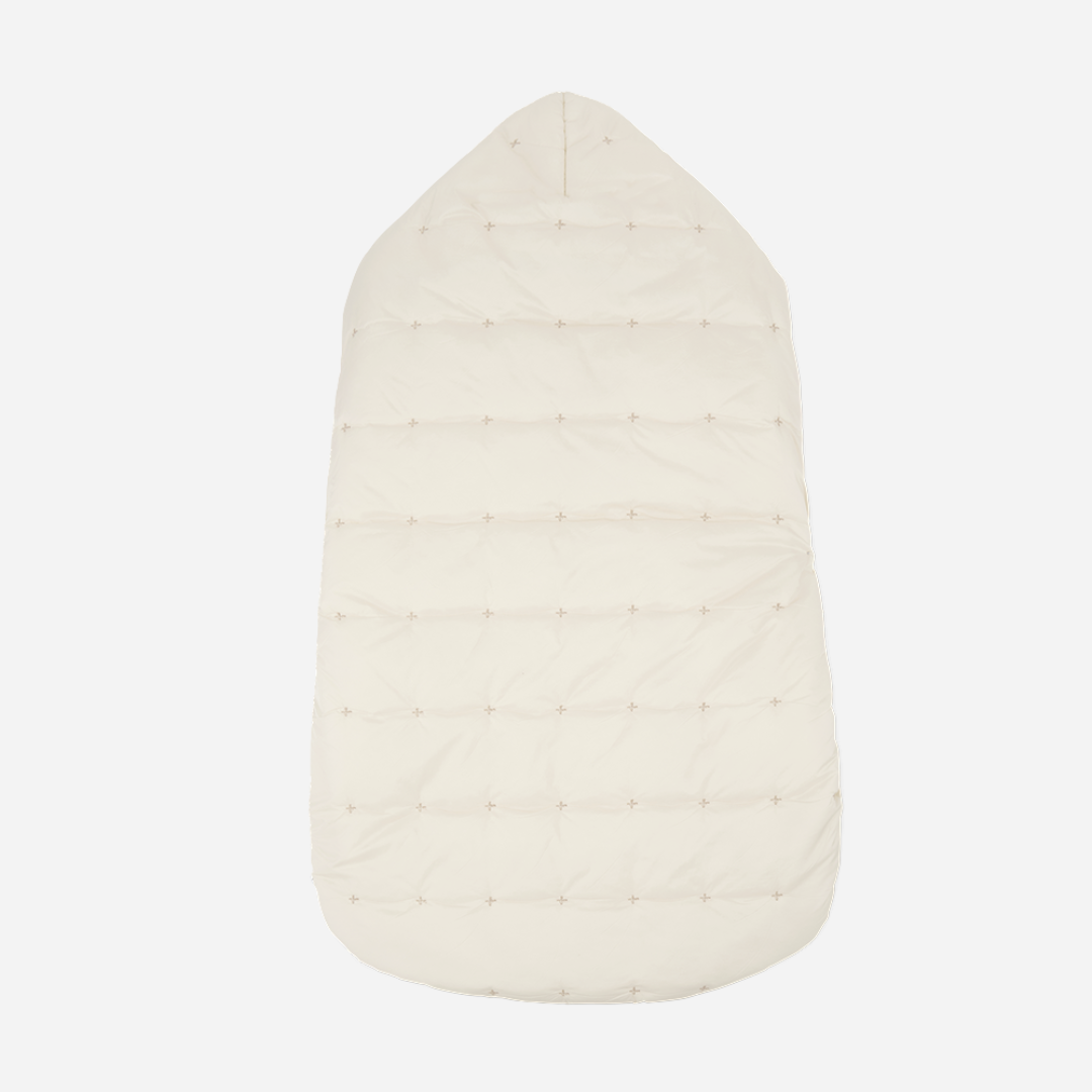 Sold at Bombon shop, designed by 1+ in the family — cream-colored quilted baby nest with hood and side button closure, crafted for warmth and comfort. back
