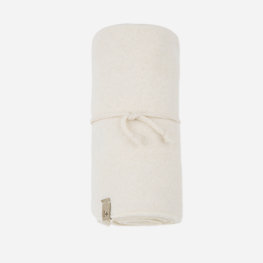 Sold at Bombon shop, designed by 1+ in the family — rolled ecru baby blanket with tie detail and soft knit texture. front
