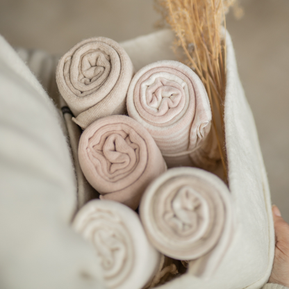 Sold at Bombon shop, designed by 1+ in the family — rolled ecru baby blanket with tie detail and soft knit texture. lifestyle