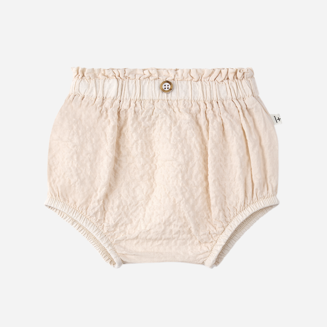 Sold at Bombon Shop, designed by 1+ in the family, blossom pink baby blouse with flutter sleeves and matching bloomers in textured cotton fabric.