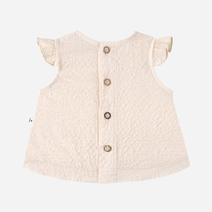 Sold at Bombon Shop, designed by 1+ in the family, blossom pink baby blouse with flutter sleeves and matching bloomers in textured cotton fabric.