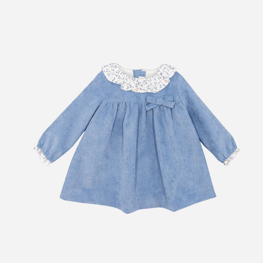 Sold at Bombon shop, designed by Fina Ejerique, a sky-blue corduroy baby dress with floral ruffle collar, bow detail, and long sleeves. front