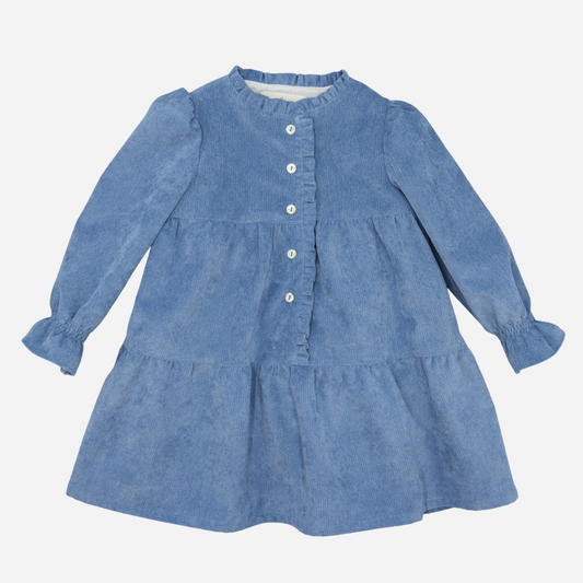 Sold at Bombon shop, designed by Fina Ejerique, a blue corduroy baby dress with ruffle trim, button front, and long sleeves. front