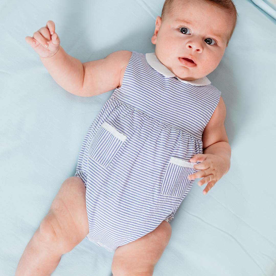 Sold at Bombon shop, designed by Fina Ejerique brand, blue striped baby romper perfect for spring and summer. Model view