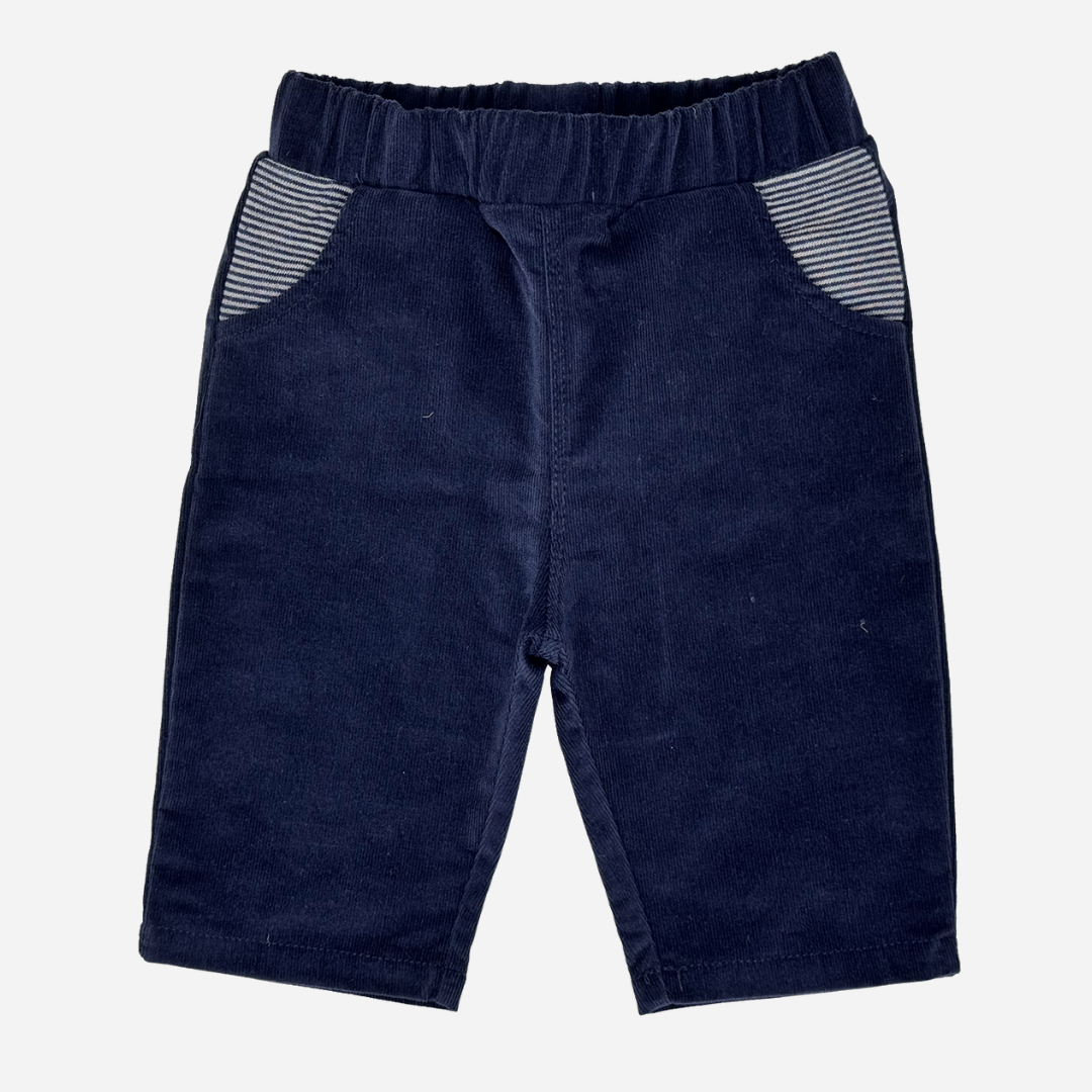 Sold at Bombon shop, designed by Tiny Soul — navy corduroy baby pants with elastic waistband and striped front pockets. front