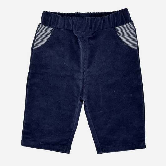 Sold at Bombon shop, designed by Tiny Soul — navy corduroy baby pants with elastic waistband and striped front pockets. front
