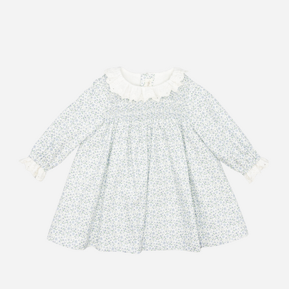Sold at Bombon shop, designed by Fina Ejerique, a white floral viyella baby dress with smocked bodice, ruffle collar, and long sleeves. front