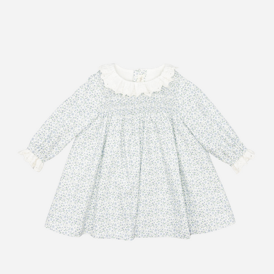 Sold at Bombon shop, designed by Fina Ejerique, a white floral viyella baby dress with smocked bodice, ruffle collar, and long sleeves. front