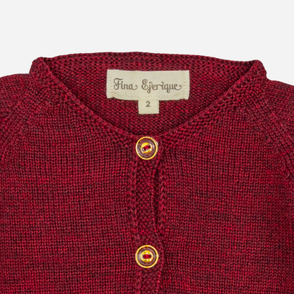Sold at Bombon shop, designed by Fina Ejerique, a burgundy knit baby cardigan with wooden buttons and scalloped trim. zoom