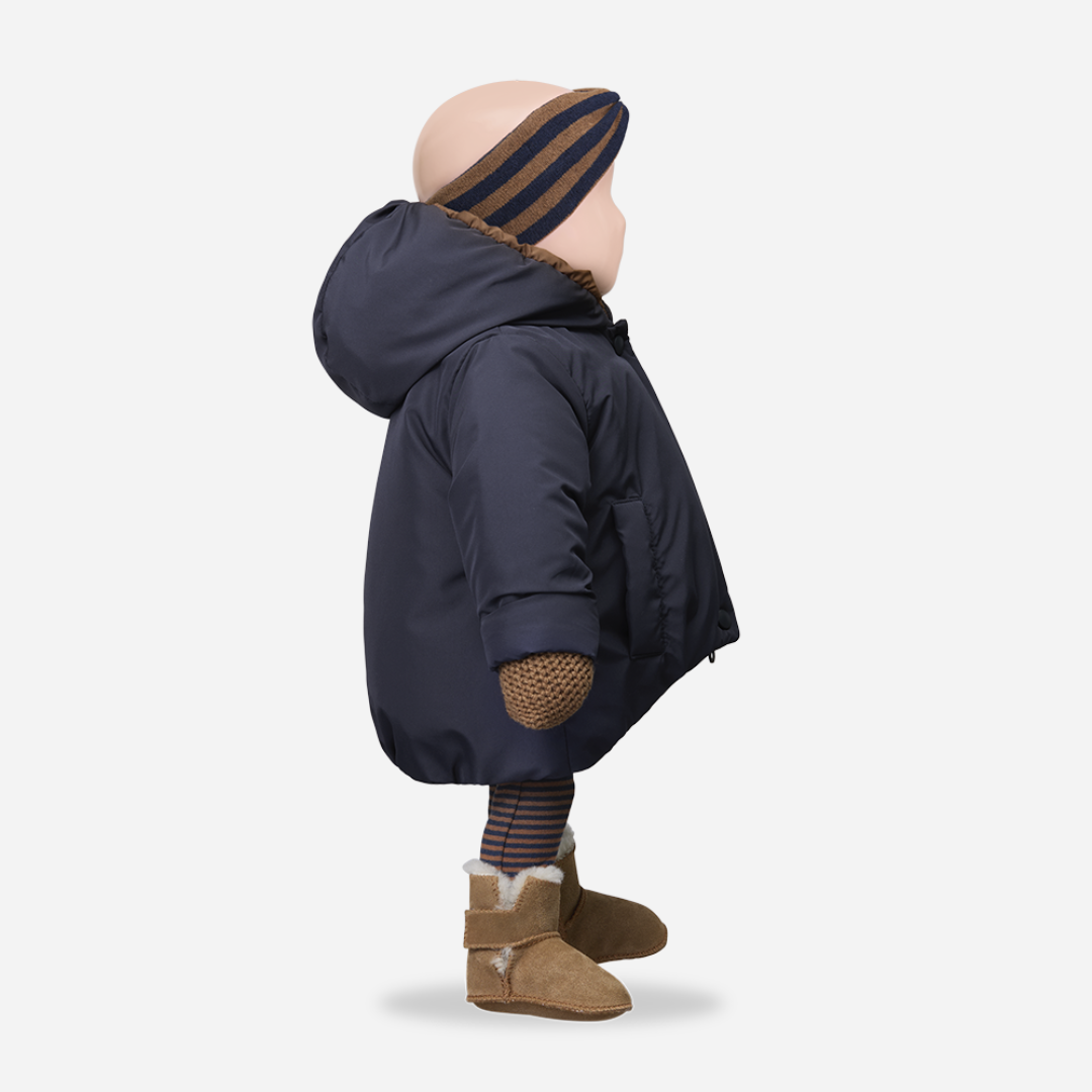 Sold at Bombon shop, designed by 1+ in the family — navy baby puffer jacket with brown lining, hood, front snaps, and patch pockets, laid flat on white background. menquin