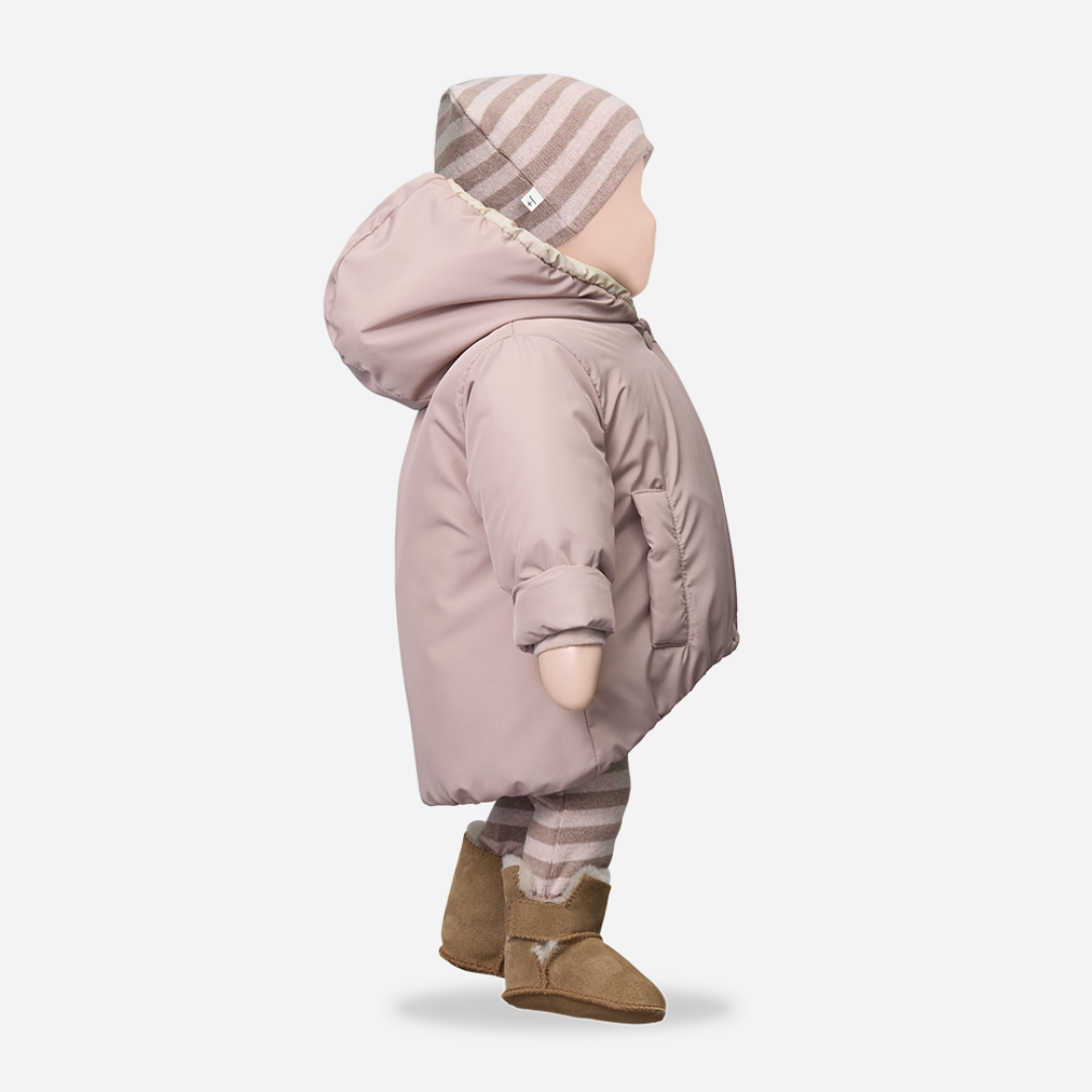 Sold at Bombon shop, designed by 1+ in the family — nude pink baby puffer jacket with cream lining, hood, snap closures, and front patch pockets, laid flat on white background. mannequin