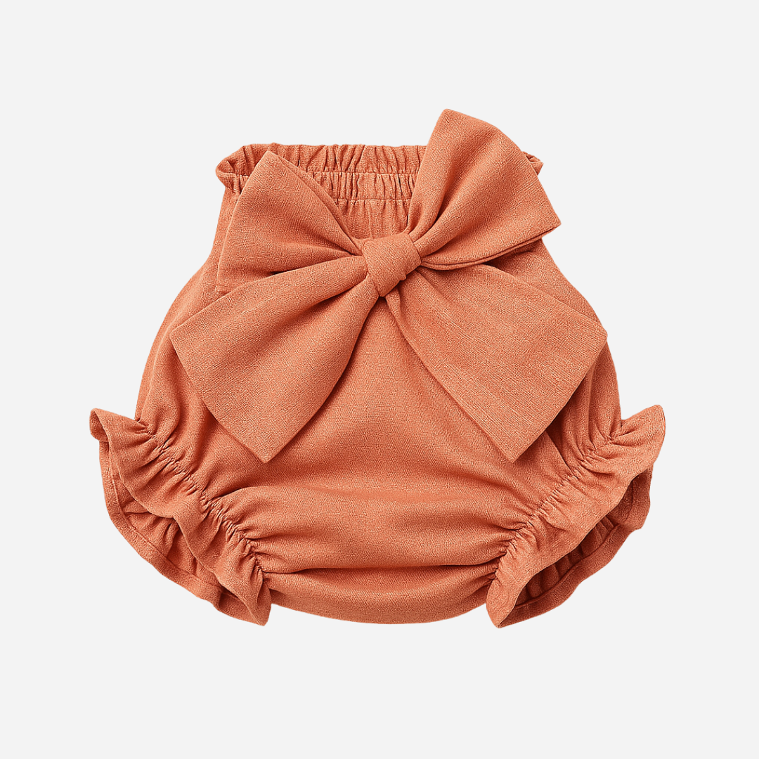 sold at Bombon shop, designed by Paloma de la O brand, this coral bow bloomer for baby girls is ideal for spring summer. front view