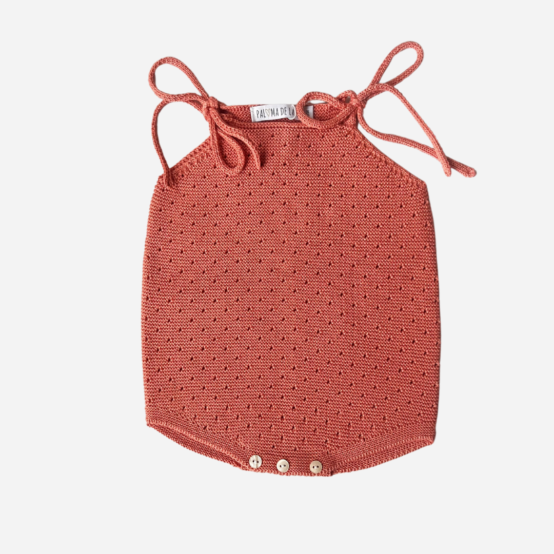 Sold at Bombon shop, designed by Paloma de la O brand, this coral romper for baby girls is ideal for spring and summer. front view. 