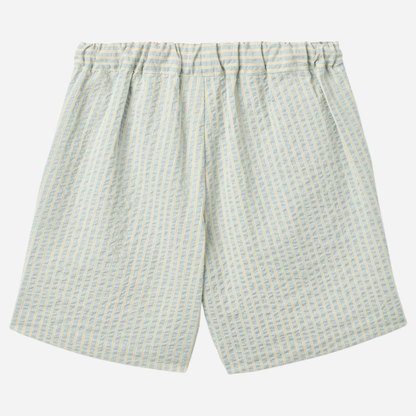 Sold at Bombon Shop, designed by Wheat, summer sky stripe organic cotton kids shorts with elastic waistband and soft blue vertical stripes.