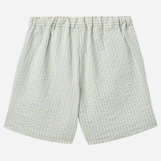 Sold at Bombon Shop, designed by Wheat, summer sky stripe organic cotton kids shorts with elastic waistband and soft blue vertical stripes.