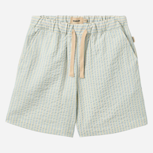Sold at Bombon Shop, designed by Wheat, summer sky stripe organic cotton kids shorts with elastic waistband and soft blue vertical stripes.