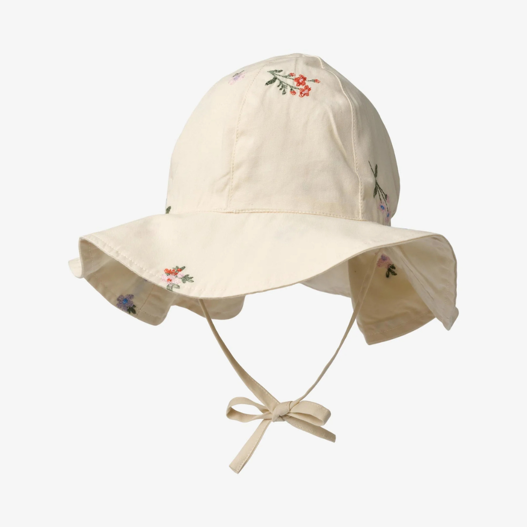 Sold at Bombon Shop, designed by Wheat, ivory organic cotton sun hat with delicate embroidered flowers and wide brim with tie detail.