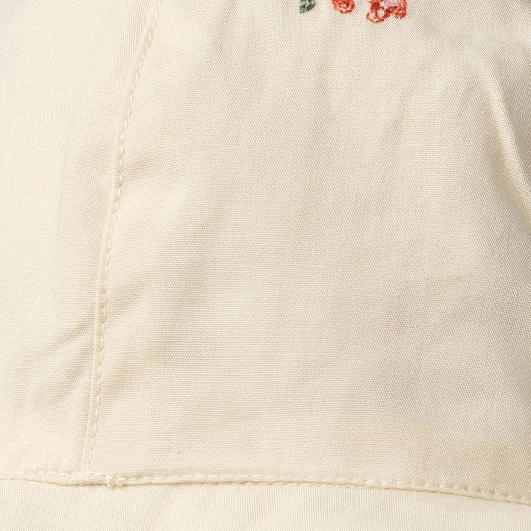 Sold at Bombon Shop, designed by Wheat, ivory organic cotton sun hat with delicate embroidered flowers and wide brim with tie detail.