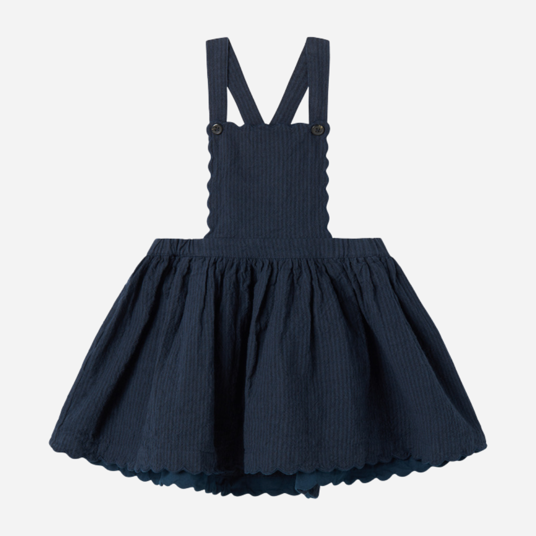 Sold at Bombon shop, designed by MarMar Copenhagen — navy 100% cotton textured pinafore dress with scalloped edges, pairs perfectly with the cream blouse.