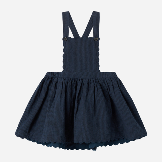 Sold at Bombon shop, designed by MarMar Copenhagen — navy 100% cotton textured pinafore dress with scalloped edges, pairs perfectly with the cream blouse.