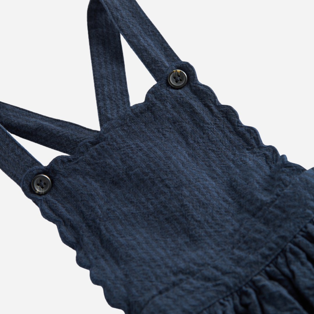 Sold at Bombon shop, designed by MarMar Copenhagen — navy 100% cotton textured pinafore dress with scalloped edges, pairs perfectly with the cream blouse.