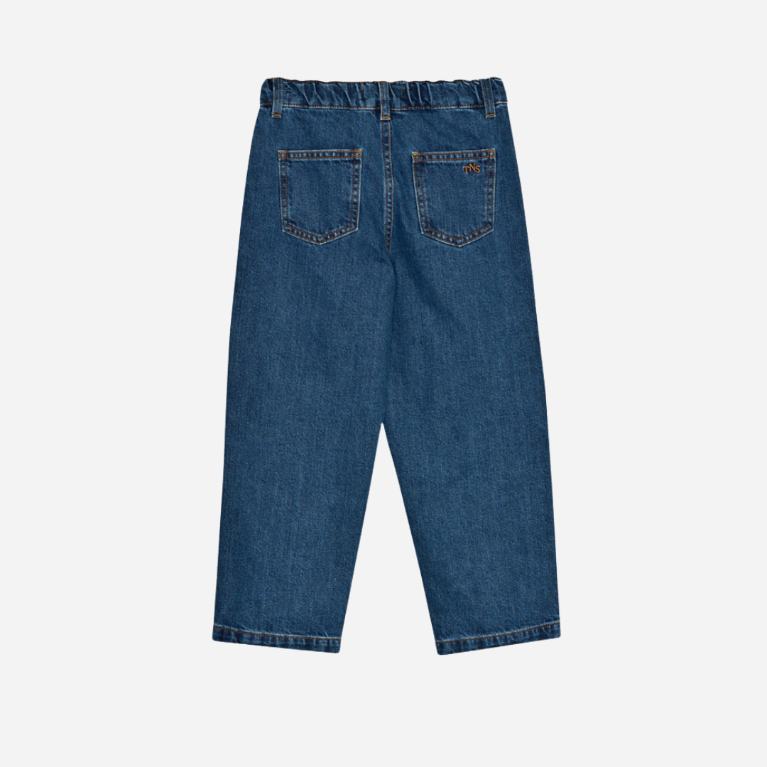 Sold at Bombon shop, these kids' denim pants by The New Society feature a relaxed, baggy fit with front patch pockets, an elastic waistband at the back, and a button closure—offering comfort and style for everyday wear. back