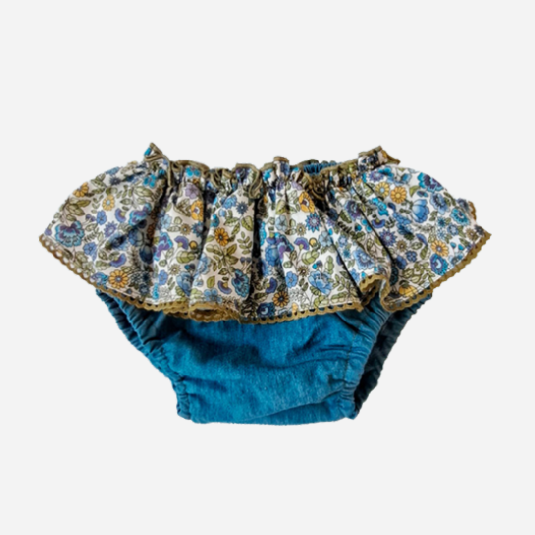 Sold at bombon shop, designed by Paloma de la O brand, this denim bottom with a flower detail for baby girls id ideal for spring and summer. front view