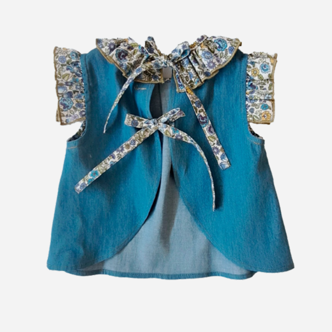 Sold at bombon shop, designed by Paloma de la O brand, this denim top with a flower collar detail for baby girls id ideal for spring and summer. back view