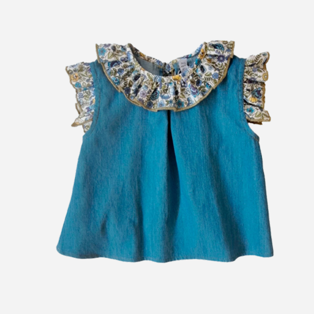 Sold at bombon shop, designed by Paloma de la O brand, this denim top with a flower collar detail for baby girls id ideal for spring and summer. front view