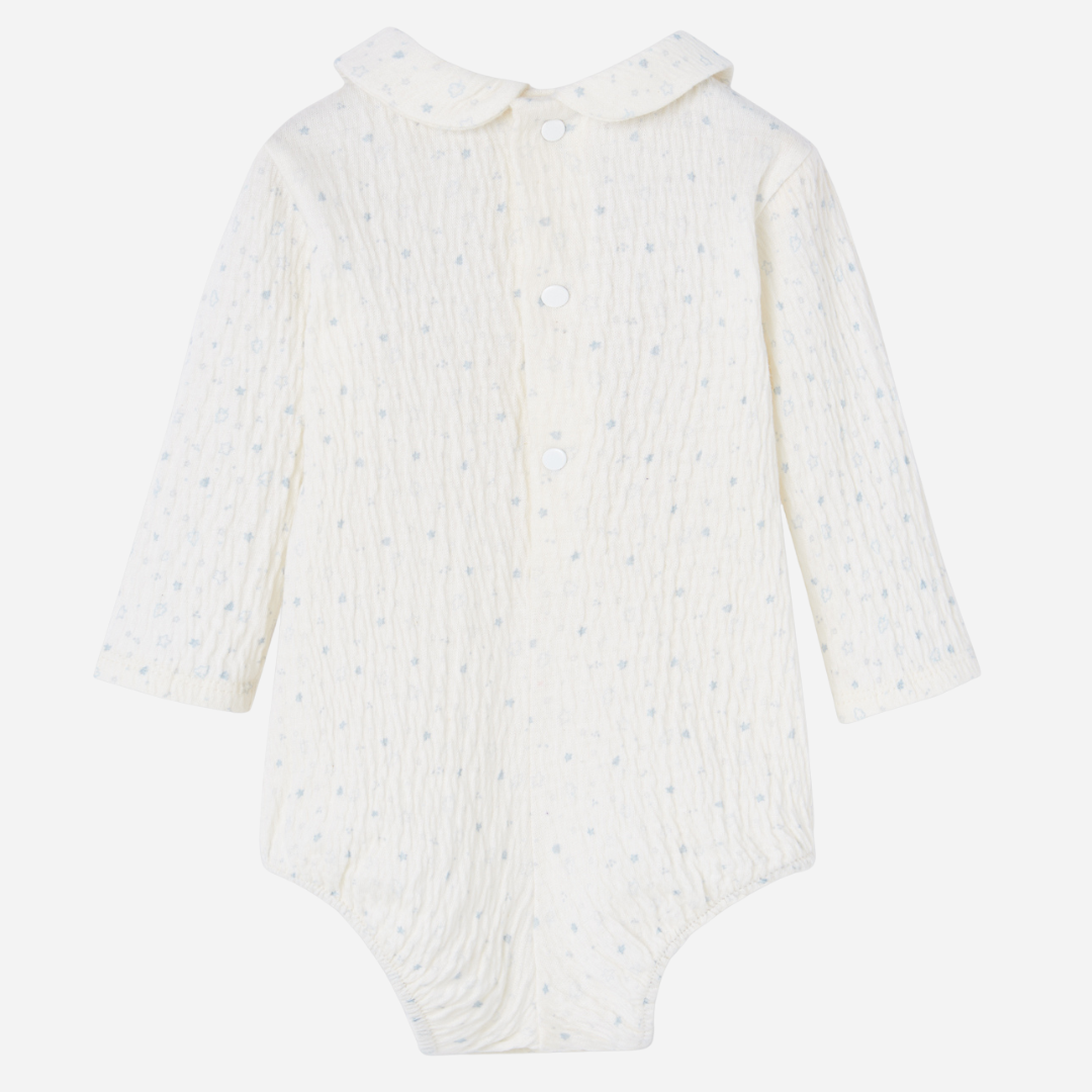 Sold at Bombon shop, designed by Paz Rodriguez, ivory baby bodysuit with blue star print and Peter Pan collar.
