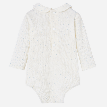 Sold at Bombon shop, designed by Paz Rodriguez, ivory baby bodysuit with blue star print and Peter Pan collar.